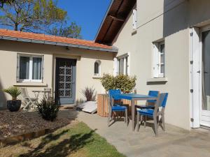 a patio with a blue table and chairs at Maison typique, centre-ville, jardin ville haute in Pornic