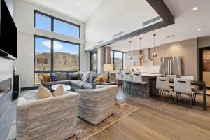 エイボンにあるOne Riverfront Condo 505 by East West Hospitalityのリビングルーム、キッチン(ソファ、椅子付)