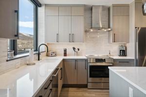 エイボンにあるOne Riverfront Condo 505 by East West Hospitalityの白いキャビネットと大きな窓のあるキッチン