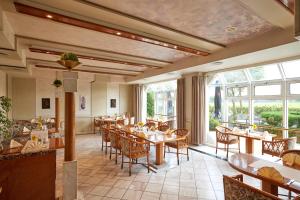 a restaurant with tables and chairs and large windows at Hotel Restaurant Stegemann in Saerbeck