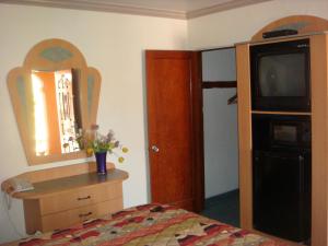 a bedroom with a bed and a dresser and a mirror at Economy Inn Los Banos in Los Banos