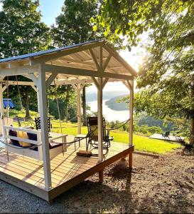 a gazebo with a hammock and a swing at TinyLakeview Cottage in Monticello