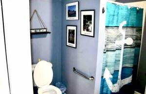 a bathroom with a toilet and pictures on the wall at TinyLakeview Cottage in Monticello