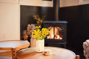 ハーパーズ・フェリーにあるRed A Frame Shenandoah Escape Fire Pit BBQの暖炉のあるテーブルの上に黄色い花の入った花瓶 +37枚の写真