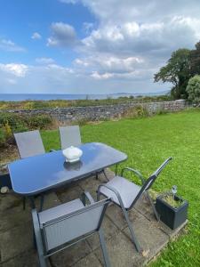 a blue table and two chairs on a lawn at Oranuisce Thatch Cottage Ballyvaughan in Ballyvaughan