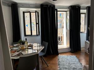a dining room with a table and black curtains at Casa Eliza in Aldeia das Dez
