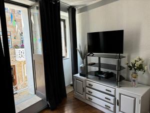 a living room with a flat screen tv on a dresser at Casa Eliza in Aldeia das Dez