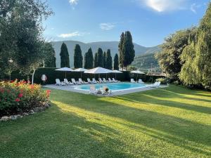 a pool with chairs and umbrellas in a yard at Villa Del Papa in Lucca