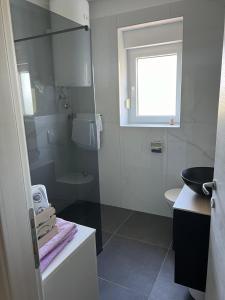 a bathroom with a sink and a toilet and a window at Vila Tatjana in Klenovica