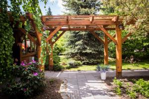 a wooden pergola in a garden at Hotel Azyl in Kąty Wrocławskie