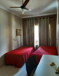 a bedroom with two beds and a ceiling fan at Chalé Luxuoso in Caldas Novas