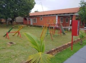 a yard with playground equipment in front of a house at Chalé Luxuoso in Caldas Novas
