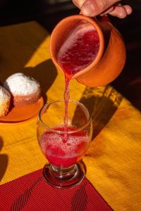 a person is pouring red liquid into a glass at Mai Jaii in Purmamarca +13 photos