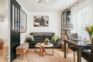a living room with a couch and a table at Chambre aspect loft in Baguer-Pican