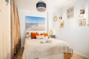 a bedroom with a bed with orange pillows on it at Chambre aspect loft in Baguer-Pican