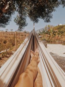 osoba leżąca w hamaku z nogami w górze w obiekcie Glamping Finca el Olivo w mieście Mijas