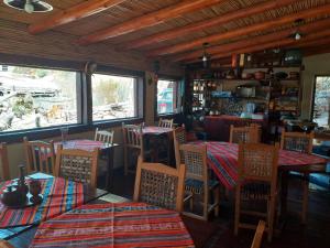 a dining room with tables and chairs and windows at Mai Jaii in Purmamarca