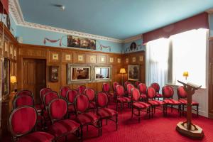 a waiting room with red chairs and a podium at Scholars Townhouse Hotel in Drogheda