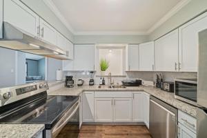 a kitchen with white cabinets and stainless steel appliances at Amazing 4BR 2BA Winter Home with Pool & Game-Movie Room in Texas City
