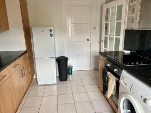 a kitchen with a white refrigerator and a trash can at Charming Seaside home Sleeps 4 with free parking in Broughty Ferry