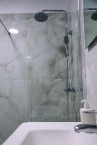 a shower with a glass door in a bathroom at Oasis Apartment Korce in Korçë +8 photos