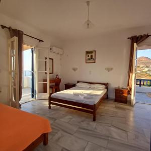a bedroom with a bed and an open door at Lofos Studios in Agios Prokopios