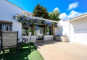 a patio with a table and purple flowers at Chalet en Puerto Marina in Benalmádena