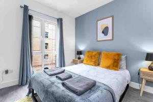 a bedroom with a bed with blue walls and a window at Seagate Heights Large, Stylish, City Centre Flat in Dundee