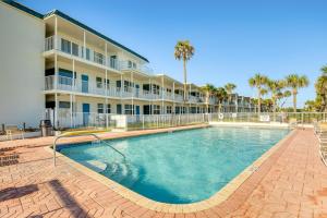 a large swimming pool in front of a building at Daytona Beach Condo with Balcony 5 Mi to Speedway! in Daytona Beach