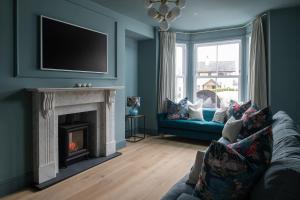 a living room with a couch and a fireplace at Camellia House in Abersoch