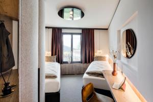 a hotel room with two beds and a table at Tinzenblick in Davos