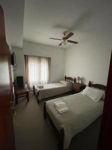 a hotel room with two beds and a ceiling fan at Hotel Guamini in Guaminí +1 photo