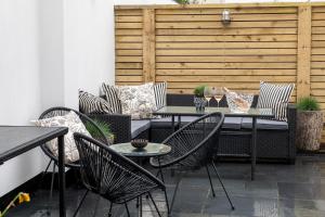 a patio with a table and chairs and a fence at Camellia House in Abersoch