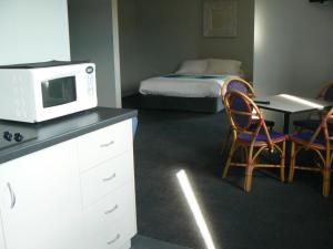 a kitchen with a microwave and a table with a bed at Centrebreak Beach Stay in Green Head