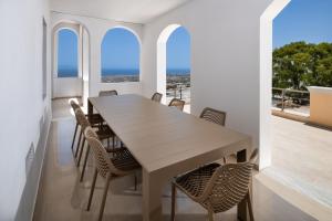 una sala da pranzo con tavolo e sedie in legno di Santorinn Suites Fira a Firà