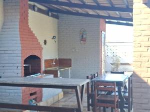 a kitchen with a brick oven and tables in a room at Mar Azul Casa de Praia in Aquiraz