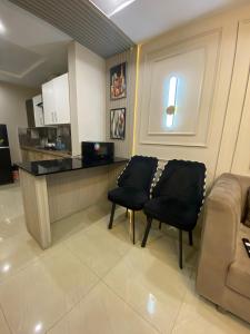 a living room with two chairs and a counter at HOME DEALS appartment in Darwāla