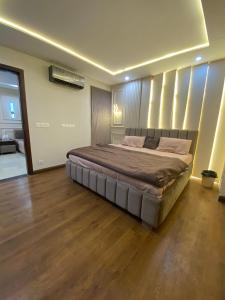 a large bed in a bedroom with a wooden floor at HOME DEALS appartment in Darwāla