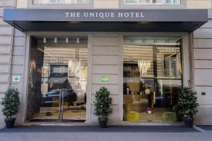a store front of a unique hotel with two plants at The Unique Hotel Brera in Milan