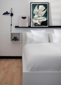 a bedroom with a white bed with two pictures on the wall at Kasa the Niche University City Philadelphia in Philadelphia