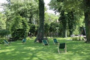 a group of lawn chairs sitting in the grass at Willa Impresja Hotel i Restauracja in Pabianice