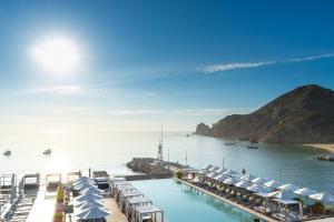 a pool with chairs and umbrellas in the water at Breathless Cabo San Lucas - Adults Only in Cabo San Lucas