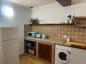 a kitchen with a washing machine and a microwave at The First Colombo Brignole XX Settembre in Genoa