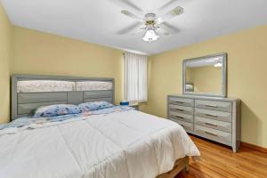 チークトワーガにあるNiagara Falls, Highmark, Buffalo Vacation Houseのベッドルーム1室(ベッド1台、鏡、天井ファン付)