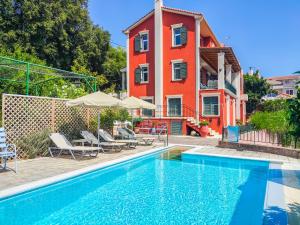 a house with a swimming pool in front of a building at Liogerma Art Deco Villa - 5 min drive to Lassi in Sarláta