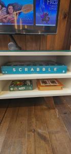 a shelf with several books on it with a tv at Recanto AlceNegro in Miguel Pereira