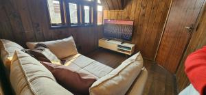 a living room with a couch and a tv at Recanto AlceNegro in Miguel Pereira