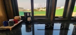 a room with a table with a coffee maker and a window at Recanto AlceNegro in Miguel Pereira