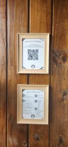 two framed signs on a wooden wall at Recanto AlceNegro in Miguel Pereira