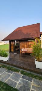 a house with a wooden deck in front of it at Recanto AlceNegro in Miguel Pereira